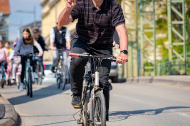 Bisiklet süren, şehirde bisiklete binen, kalabalık içinde araba kullanan bir grup genç, trafikteki ve kentsel çevredeki bisikletçiler için tehlikelere dikkat çekmeye çalışıyor.. 