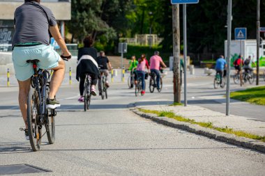 Bisiklet süren, şehirde bisiklete binen, kalabalık içinde araba kullanan bir grup genç, trafikteki ve kentsel çevredeki bisikletçiler için tehlikelere dikkat çekmeye çalışıyor.. 