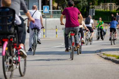 Bisiklet süren, şehirde bisiklete binen, kalabalık içinde araba kullanan bir grup genç, trafikteki ve kentsel çevredeki bisikletçiler için tehlikelere dikkat çekmeye çalışıyor.. 