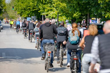 Bisiklet süren, şehirde bisiklete binen, kalabalık içinde araba kullanan bir grup genç, trafikteki ve kentsel çevredeki bisikletçiler için tehlikelere dikkat çekmeye çalışıyor.. 