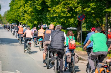 Bisiklet süren, şehirde bisiklete binen, kalabalık içinde araba kullanan bir grup genç, trafikteki ve kentsel çevredeki bisikletçiler için tehlikelere dikkat çekmeye çalışıyor.. 