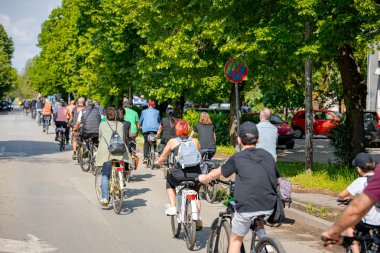 Bisiklet süren, şehirde bisiklete binen, kalabalık içinde araba kullanan bir grup genç, trafikteki ve kentsel çevredeki bisikletçiler için tehlikelere dikkat çekmeye çalışıyor.. 