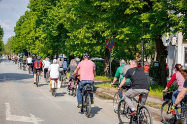 Bisiklet süren, şehirde bisiklete binen, kalabalık içinde araba kullanan bir grup genç, trafikteki ve kentsel çevredeki bisikletçiler için tehlikelere dikkat çekmeye çalışıyor.. 