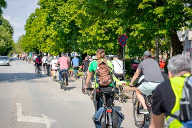 Bisiklet süren, şehirde bisiklete binen, kalabalık içinde araba kullanan bir grup genç, trafikteki ve kentsel çevredeki bisikletçiler için tehlikelere dikkat çekmeye çalışıyor.. 