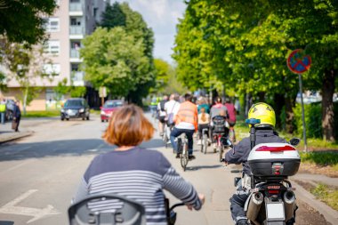 Polis memuru motosikletini tam üniformalı bir şekilde sürüyordu. Gruptaki insanları bisiklet sürerken, şehirde bisiklet sürerken, kalabalıkta sürüyordu. Trafikteki, kentsel çevredeki bisikletçiler için tehlike arz ediyordu.. 