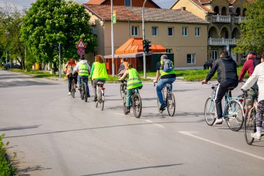 Bisiklet süren, şehirde bisiklete binen, kalabalık içinde araba kullanan bir grup genç, trafikteki ve kentsel çevredeki bisikletçiler için tehlikelere dikkat çekmeye çalışıyor.. 