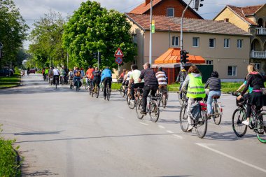 Bisiklet süren, şehirde bisiklete binen, kalabalık içinde araba kullanan bir grup genç, trafikteki ve kentsel çevredeki bisikletçiler için tehlikelere dikkat çekmeye çalışıyor.. 