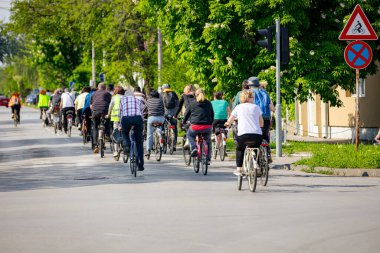 Bisiklet süren, şehirde bisiklete binen, kalabalık içinde araba kullanan bir grup genç, trafikteki ve kentsel çevredeki bisikletçiler için tehlikelere dikkat çekmeye çalışıyor.. 