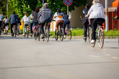 Bisiklet süren, şehirde bisiklete binen, kalabalık içinde araba kullanan bir grup genç, trafikteki ve kentsel çevredeki bisikletçiler için tehlikelere dikkat çekmeye çalışıyor.. 