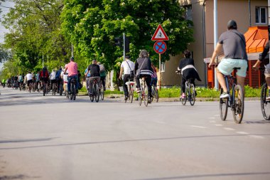 Bisiklet süren, şehirde bisiklete binen, kalabalık içinde araba kullanan bir grup genç, trafikteki ve kentsel çevredeki bisikletçiler için tehlikelere dikkat çekmeye çalışıyor.. 