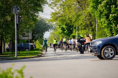Bisiklet süren, şehirde bisiklete binen, kalabalık içinde araba kullanan bir grup genç, trafikteki ve kentsel çevredeki bisikletçiler için tehlikelere dikkat çekmeye çalışıyor.. 