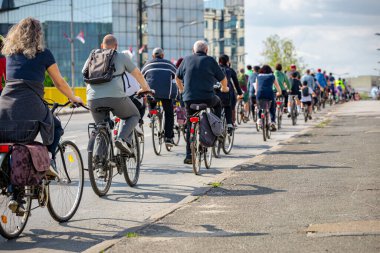 Bisiklet süren, şehirde bisiklete binen, kalabalık içinde araba kullanan bir grup genç, trafikteki ve kentsel çevredeki bisikletçiler için tehlikelere dikkat çekmeye çalışıyor.. 