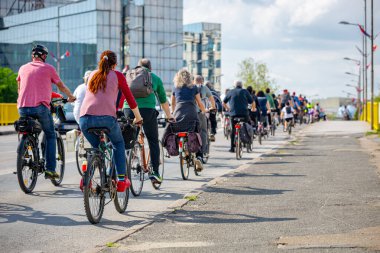 Bisiklet süren, şehirde bisiklete binen, kalabalık içinde araba kullanan bir grup genç, trafikteki ve kentsel çevredeki bisikletçiler için tehlikelere dikkat çekmeye çalışıyor.. 