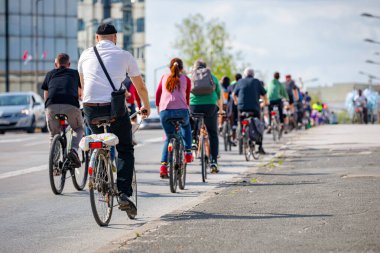 Bisiklet süren, şehirde bisiklete binen, kalabalık içinde araba kullanan bir grup genç, trafikteki ve kentsel çevredeki bisikletçiler için tehlikelere dikkat çekmeye çalışıyor.. 