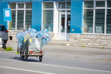 Motosiklete bağlı yüklü karavan, içi boş plastik şişelerle dolu bisiklet, geri dönüşüm için toplanan atık