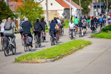 Bisiklet süren, şehirde bisiklete binen, kalabalık içinde araba kullanan bir grup genç, trafikteki ve kentsel çevredeki bisikletçiler için tehlikelere dikkat çekmeye çalışıyor.. 
