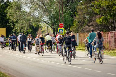 Bisiklet süren, şehirde bisiklete binen, kalabalık içinde araba kullanan bir grup genç, trafikteki ve kentsel çevredeki bisikletçiler için tehlikelere dikkat çekmeye çalışıyor.. 