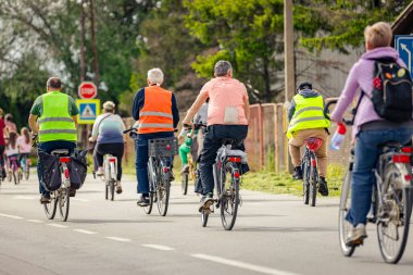 Bisiklet süren, şehirde bisiklete binen, kalabalık içinde araba kullanan bir grup genç, trafikteki ve kentsel çevredeki bisikletçiler için tehlikelere dikkat çekmeye çalışıyor.. 