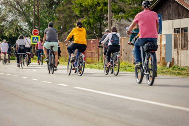 Bisiklet süren, şehirde bisiklete binen, kalabalık içinde araba kullanan bir grup genç, trafikteki ve kentsel çevredeki bisikletçiler için tehlikelere dikkat çekmeye çalışıyor.. 