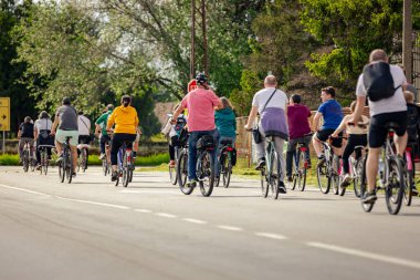 Bisiklet süren, şehirde bisiklete binen, kalabalık içinde araba kullanan bir grup genç, trafikteki ve kentsel çevredeki bisikletçiler için tehlikelere dikkat çekmeye çalışıyor.. 