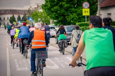 Bisiklet süren, şehirde bisiklete binen, kalabalık içinde araba kullanan bir grup genç, trafikteki ve kentsel çevredeki bisikletçiler için tehlikelere dikkat çekmeye çalışıyor.. 