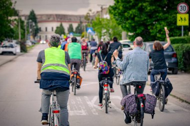 Bisiklet süren, şehirde bisiklete binen, kalabalık içinde araba kullanan bir grup genç, trafikteki ve kentsel çevredeki bisikletçiler için tehlikelere dikkat çekmeye çalışıyor.. 