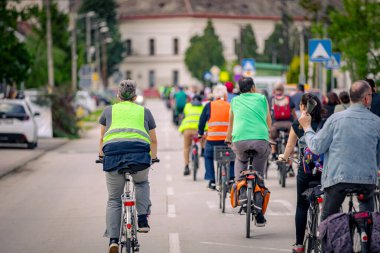 Bisiklet süren, şehirde bisiklete binen, kalabalık içinde araba kullanan bir grup genç, trafikteki ve kentsel çevredeki bisikletçiler için tehlikelere dikkat çekmeye çalışıyor.. 