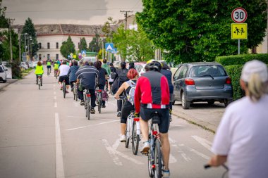 Bisiklet süren, şehirde bisiklete binen, kalabalık içinde araba kullanan bir grup genç, trafikteki ve kentsel çevredeki bisikletçiler için tehlikelere dikkat çekmeye çalışıyor.. 
