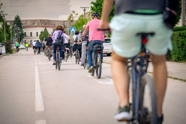 Bisiklet süren, şehirde bisiklete binen, kalabalık içinde araba kullanan bir grup genç, trafikteki ve kentsel çevredeki bisikletçiler için tehlikelere dikkat çekmeye çalışıyor.. 