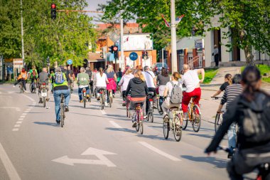 Bisiklet süren, şehirde bisiklete binen, kalabalık içinde araba kullanan bir grup genç, trafikteki ve kentsel çevredeki bisikletçiler için tehlikelere dikkat çekmeye çalışıyor.. 
