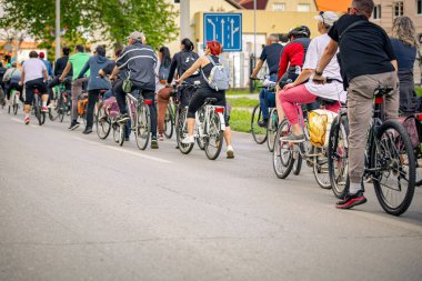 Bisiklet süren, şehirde bisiklete binen, kalabalık içinde araba kullanan bir grup genç, trafikteki ve kentsel çevredeki bisikletçiler için tehlikelere dikkat çekmeye çalışıyor.. 