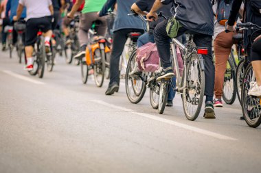 Bisiklet süren, şehirde bisiklete binen, kalabalık içinde araba kullanan bir grup genç, trafikteki ve kentsel çevredeki bisikletçiler için tehlikelere dikkat çekmeye çalışıyor.. 