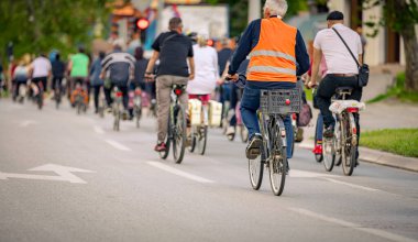 Bisiklet süren, şehirde bisiklete binen, kalabalık içinde araba kullanan bir grup genç, trafikteki ve kentsel çevredeki bisikletçiler için tehlikelere dikkat çekmeye çalışıyor.. 