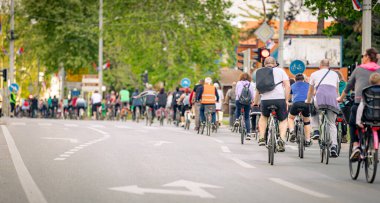Bisiklet süren, şehirde bisiklete binen, kalabalık içinde araba kullanan bir grup genç, trafikteki ve kentsel çevredeki bisikletçiler için tehlikelere dikkat çekmeye çalışıyor.. 