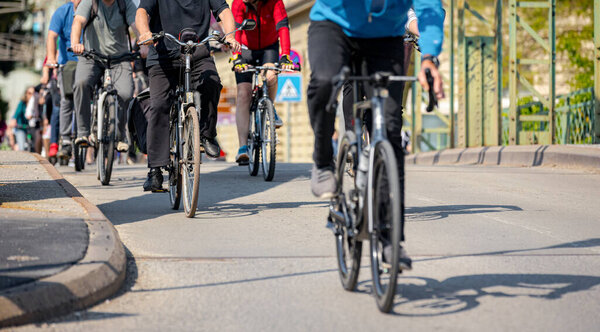 Группа молодых людей ездит на велосипеде, ездит на велосипеде по городу, едет в толпе они пытаются привлечь внимание к опасности для велосипедистов в движении, городской среде. 