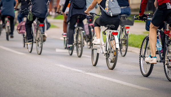Группа молодых людей ездит на велосипеде, ездит на велосипеде по городу, едет в толпе они пытаются привлечь внимание к опасности для велосипедистов в движении, городской среде. 
