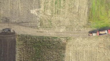 En tepede, iki boş karavanla traktörün üzerinden geçen kule kırsal yoldaki tarımsal araziler arasında gidip tozlu zemin yolunda ilerliyor..