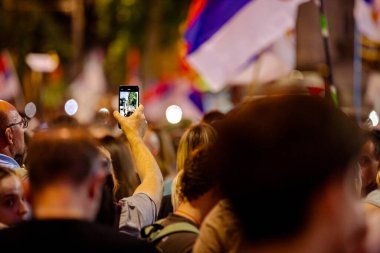 Fotoğraf çekmek için cep telefonu bulundurmak, hükümet yolsuzluklarını, rejimi protesto videolarını kaydetmek, trajik bir kazada hayatını kaybedenler için adalet talep etmek, Sırbistan 'ın Novi Sad kentindeki demiryolu istasyonu