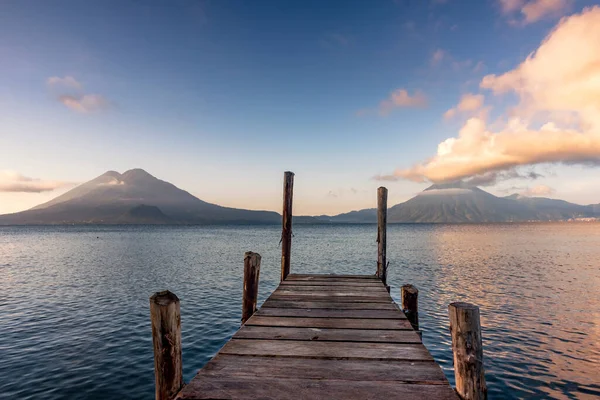 Volcanoes and dock on lake Atitlan at sunrise