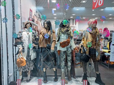Polonya, Bydgoszcz - 13 Ocak 2022: Kadın mankenler şık bir kış kıyafeti sergilemektedir. Vitrindeki güzel bebekler. Moda ve stil mağazası önü
