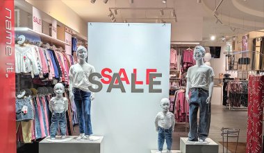 Avusturya, Viyana - 9 Ocak 2023: NAME IT, 0-16 yaş arası çocuk kıyafetleri konusunda uzmanlaşmış Danimarkalı giyim markası. Vitrinde duran bebek mankenler. Beyaz poster indirimi 