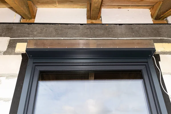 Warm installation of a three-layer window with a polystyrene window sill, view from the outside.