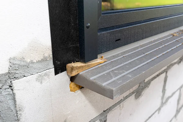 Warm installation of a three-layer window with a polystyrene window sill, view from the outside.