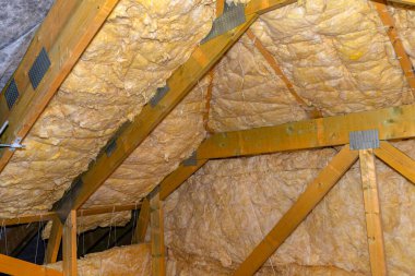 Çatı katında kirişler arasındaki mineral yünden yapılmış duvar ve tavan izolasyonu, polipropilen iplikle bağlanmış..