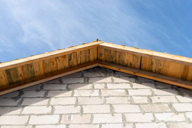 Çatının tepesi tamamen tahtalarla kaplı. Ham duvarlar ve çatı kirişleri görülebiliyor..