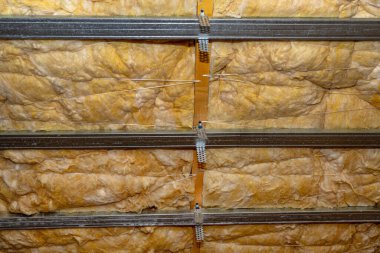 Aluminum frame with hangers placed on beams in the attic for mounting plasterboards.