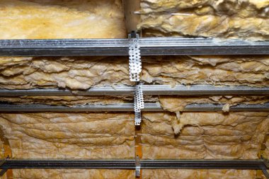 Aluminum frame with hangers placed on beams in the attic for mounting plasterboards.