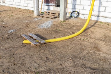 Çatıdaki hendeğin ucuna bağlı 100 mm çapında sarı PVC boru, sudan korunuyor..