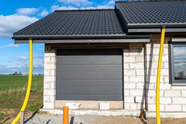 Çatıdaki hendeğin ucuna bağlı 100 mm çapında sarı PVC boru, sudan korunuyor..