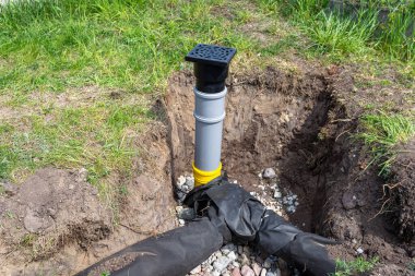 Taşlarla kaplı bir çukura gömülü drenaj borularına iyi bağlanmış taşkın ve sızma.